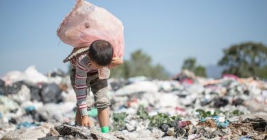 Un bambino che fruga fra i rifiuti di una discarica